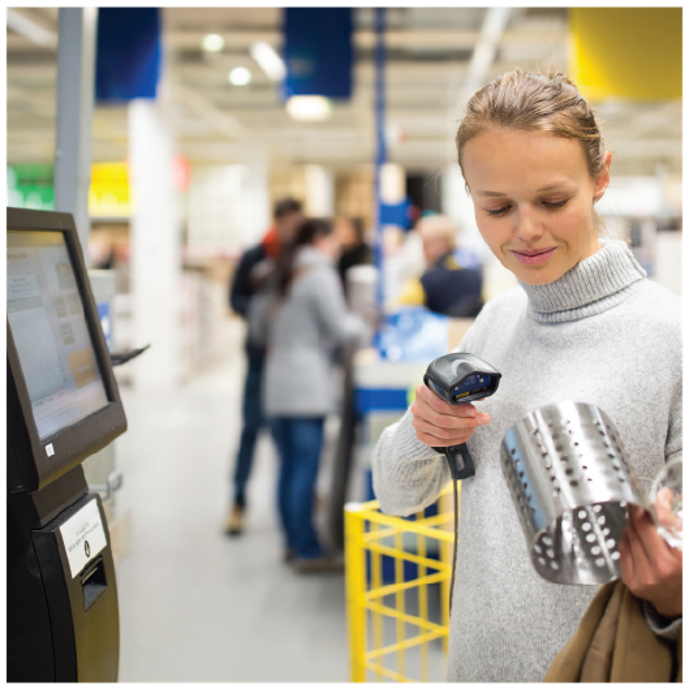 A woman using self service to pay for home goods.